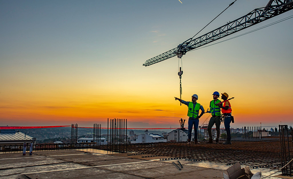 Construction workers at sunset